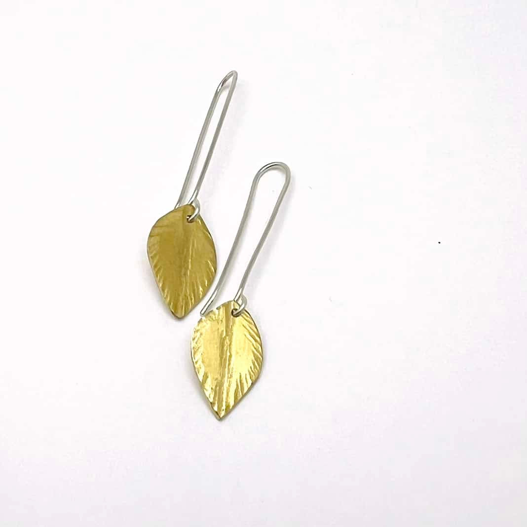 Silver and brass earrings with brass leaf suspended from silver ear wire