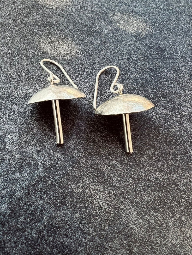 Pair of silver earrings on a gray textured background