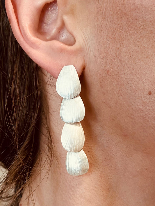 Close-up of a woman wearing a shell-shaped earring.