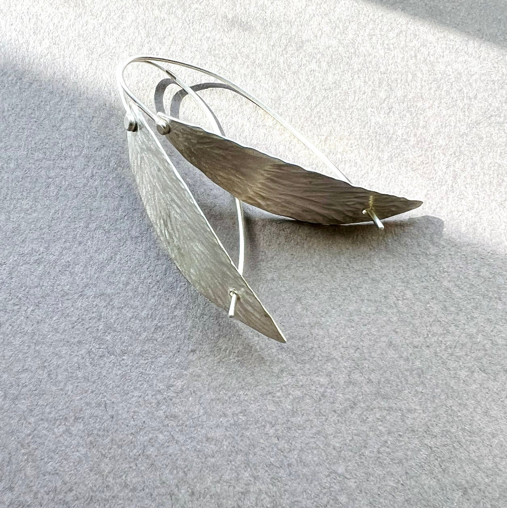 Silver willow leaf-shaped earrings on a light gray background