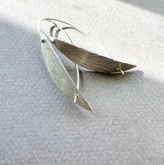 Silver willow leaf-shaped earrings on a light gray background