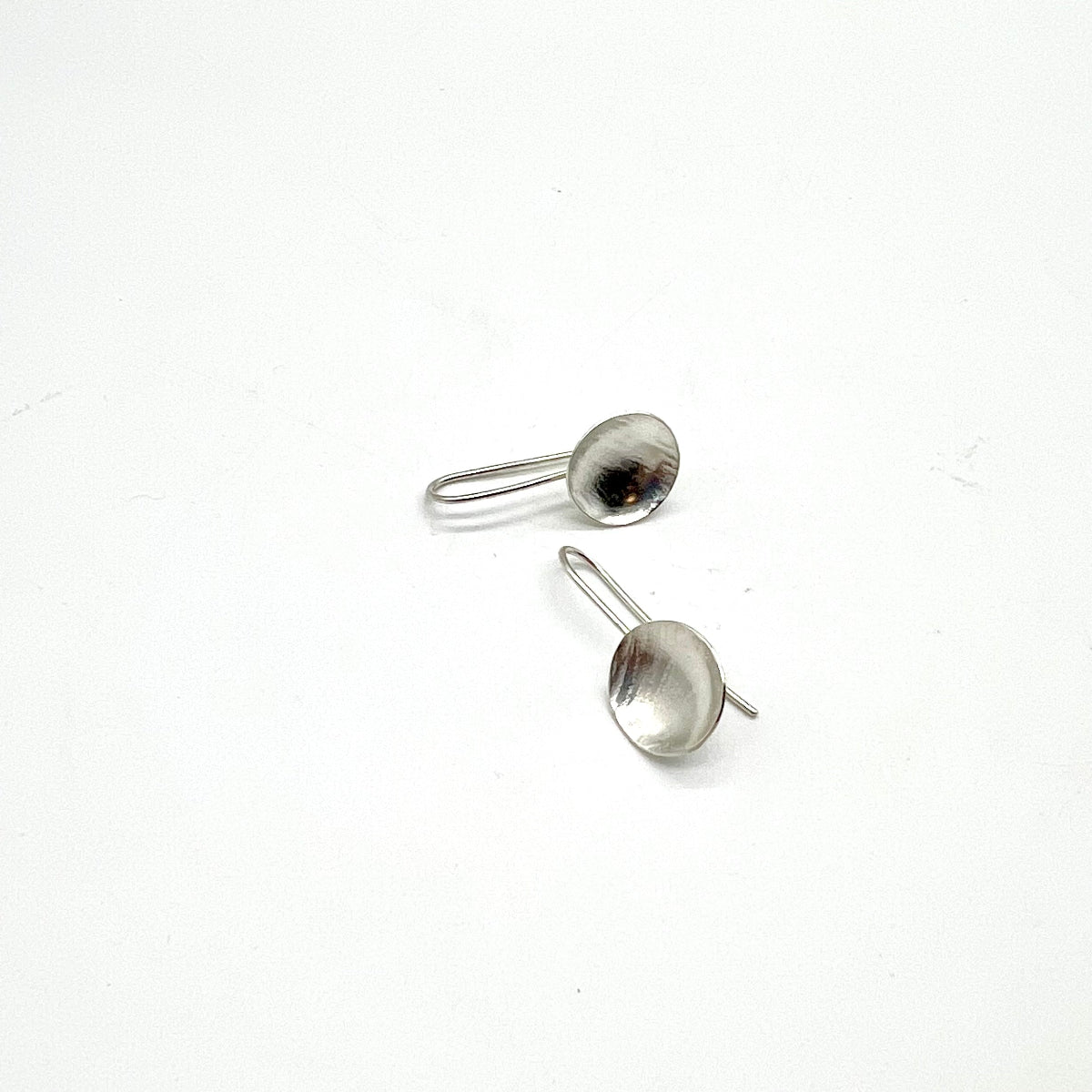 Pair of silver dome earrings on a white background