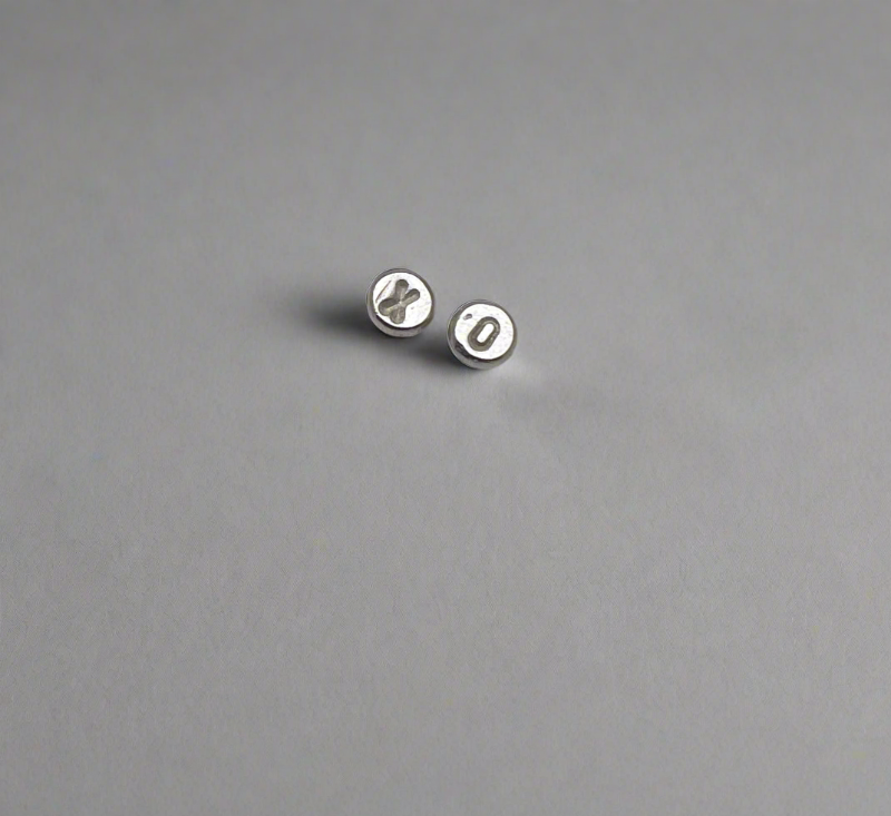 Pair of XO silver earrings on a gray background